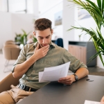 jeune homme lisant des fiches de formation en entreprise